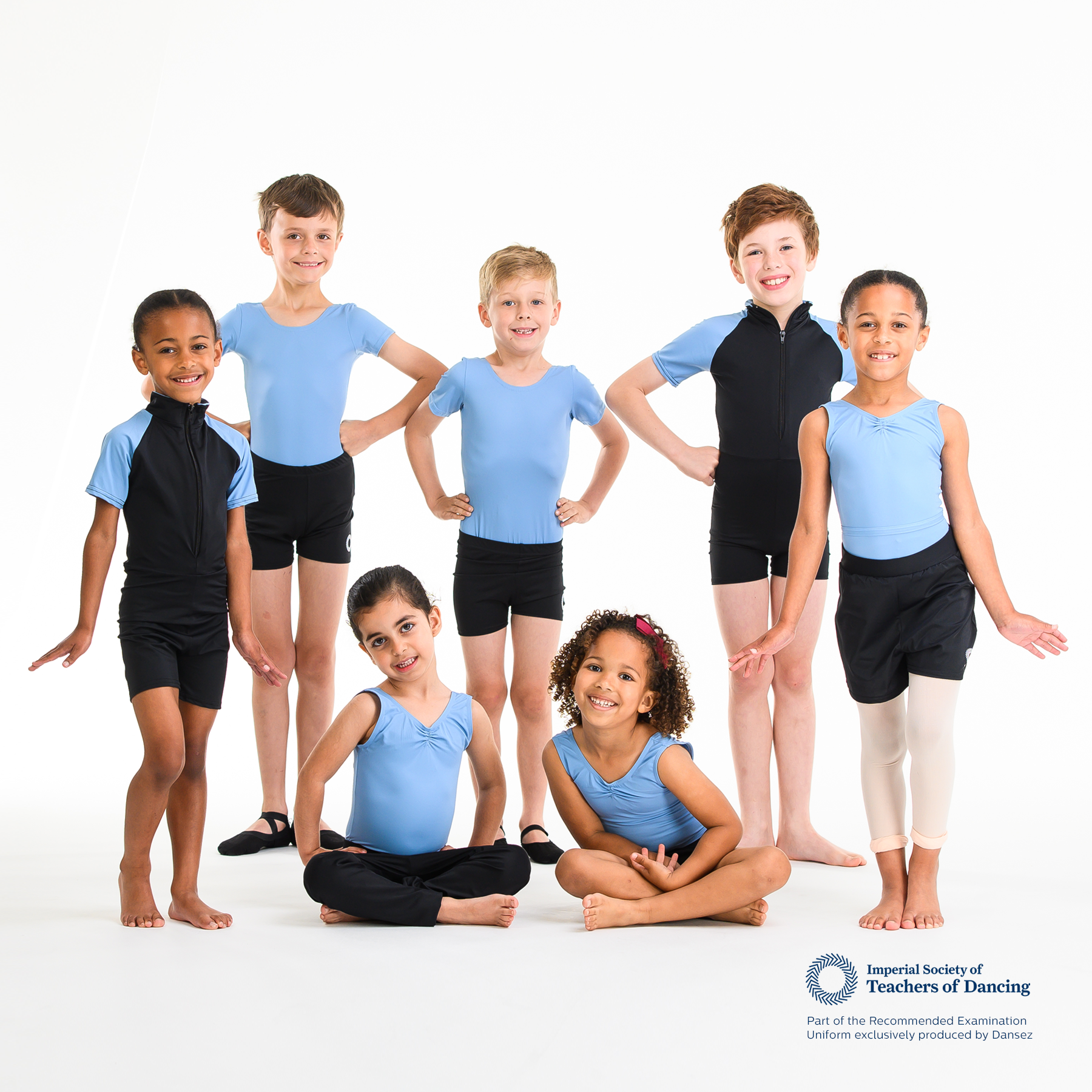 A group of young dancers wearing a selection of blue ISTD leotards and shorts
