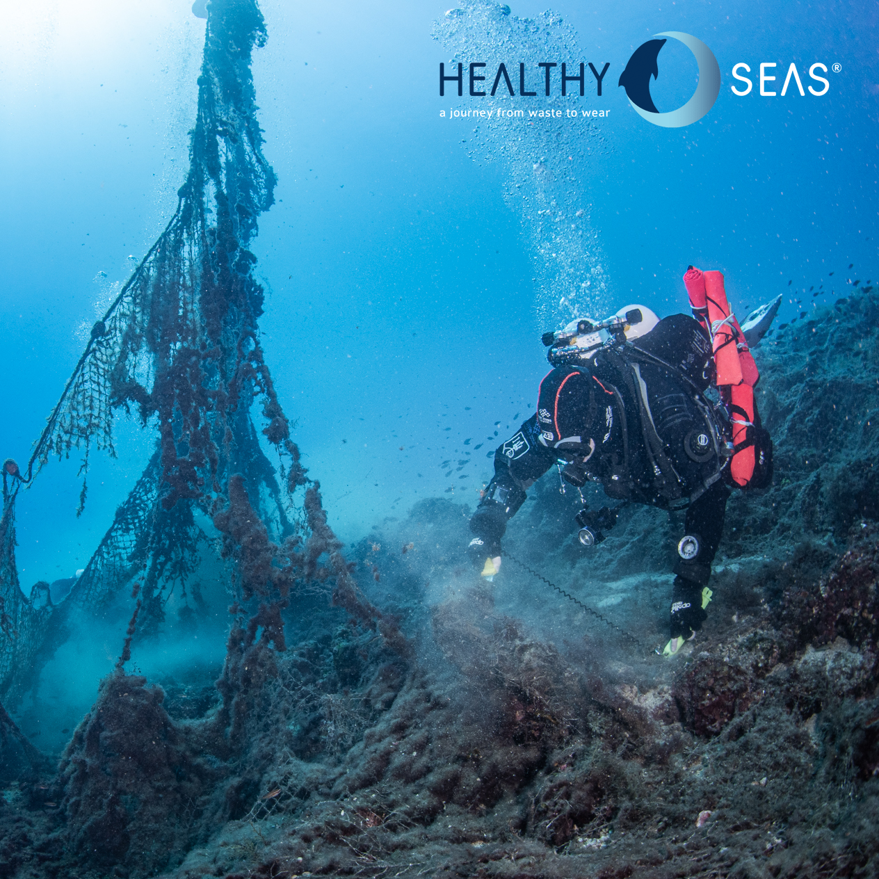 Diver collecting ghost fishing nets from the bottom of the ocean with Healthy Seas logo