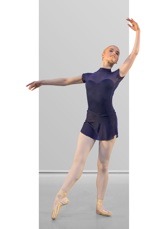 Ballerina in a navy blue leotard and skirt posing against a gray background