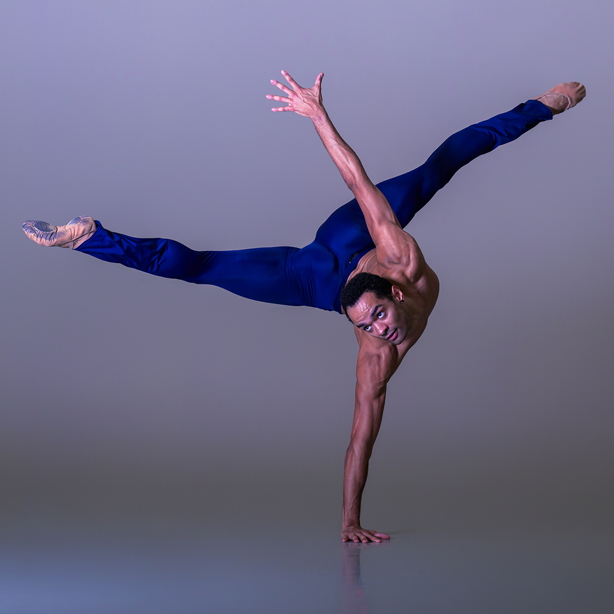 Brandon Lawrence balancing on one hand in blue leggings