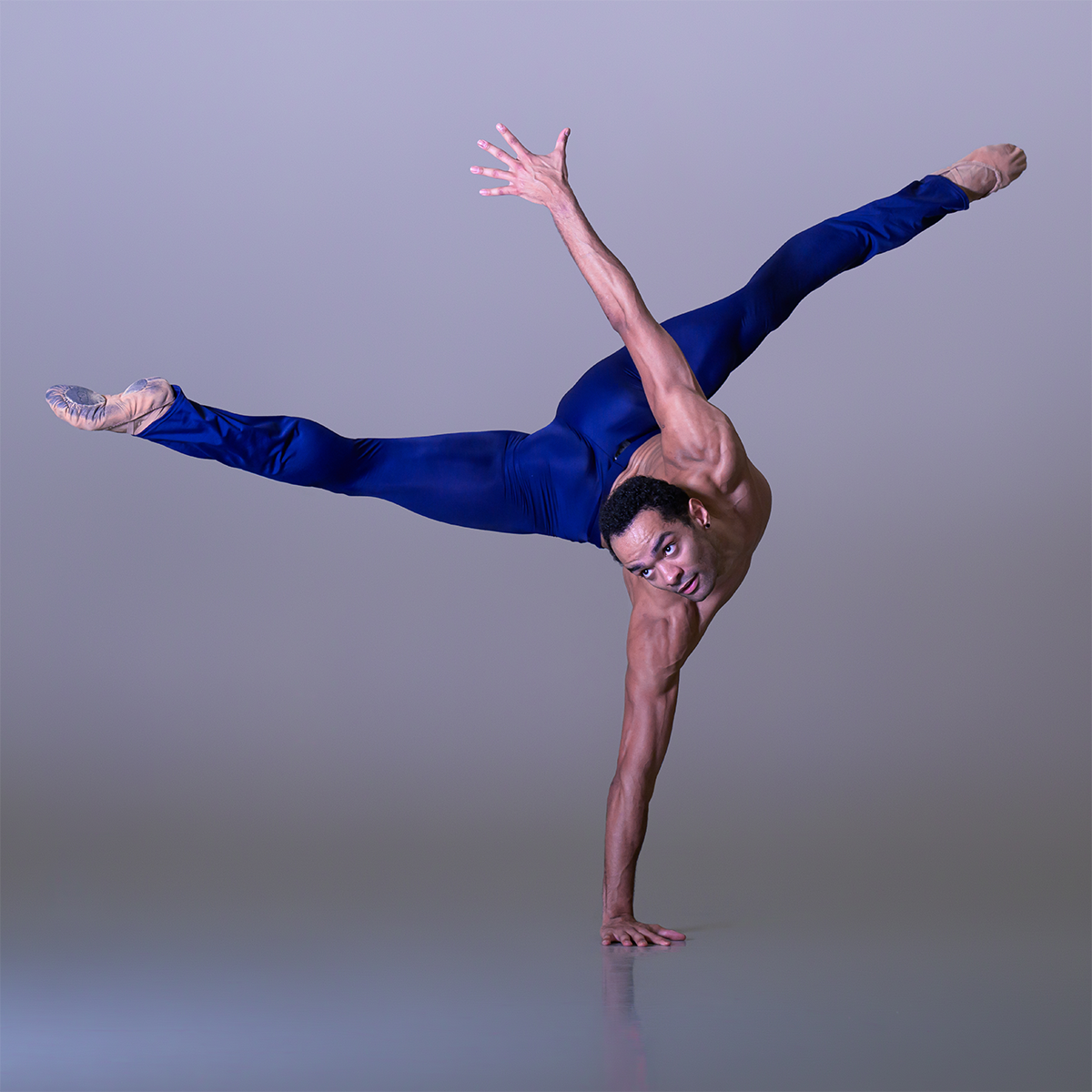 Brandon Lawrence balancing on one hand wearing blue leggings