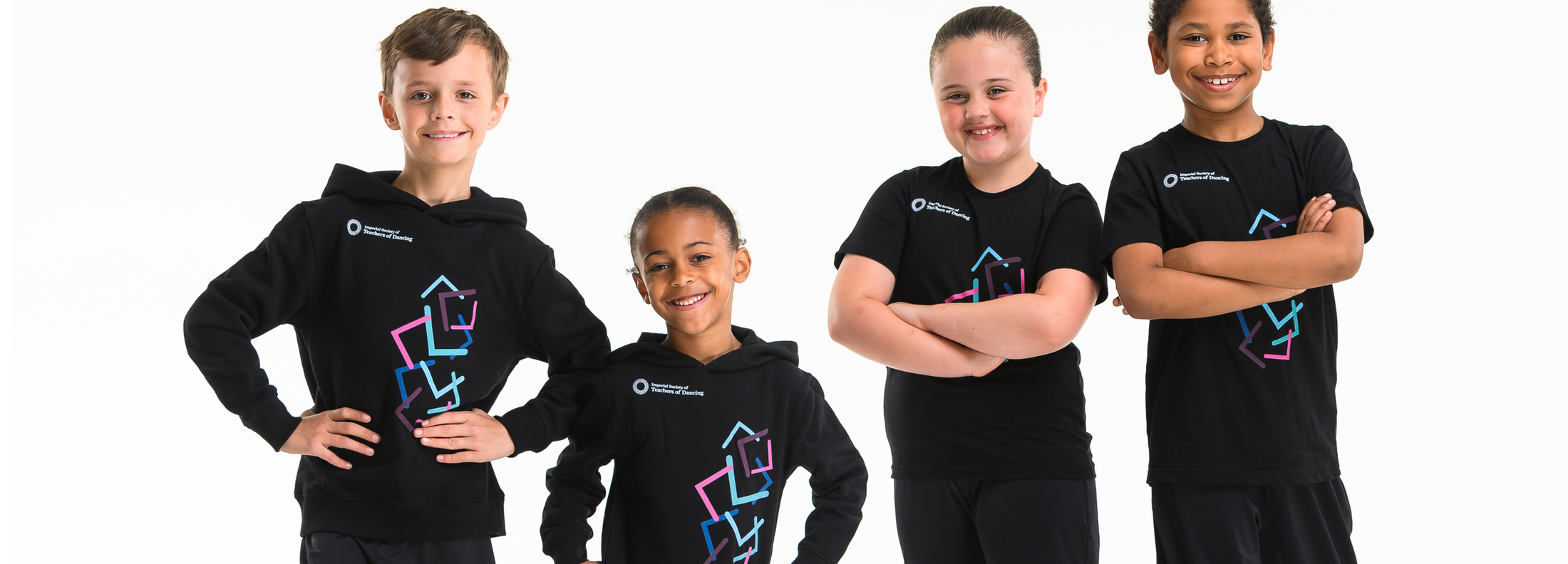 A group four young dancers wearing ISTD hoodies and t-shirts