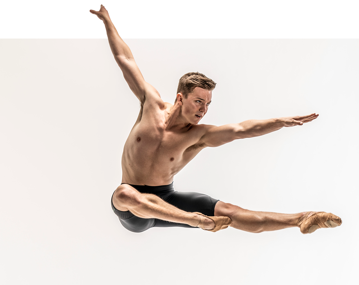 Leaping male Birmingham Royal Ballet dancer wearing Brandon Lawrence by Dansez shorts