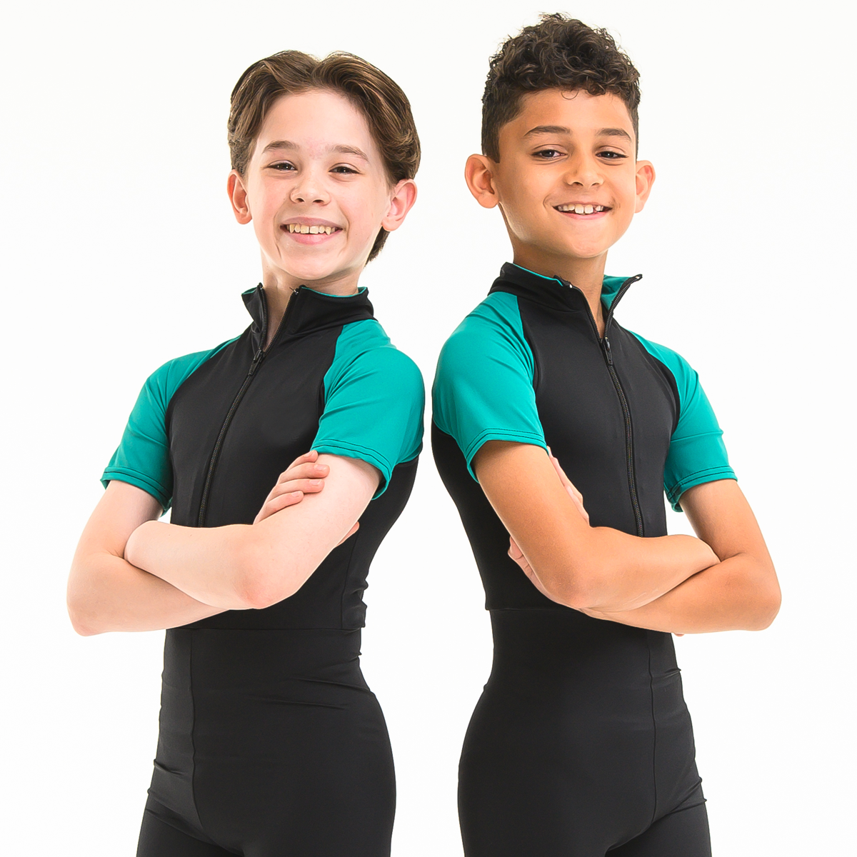 Two junior boys posed back to back wearing ISTD green and black zip front unitards on a white background