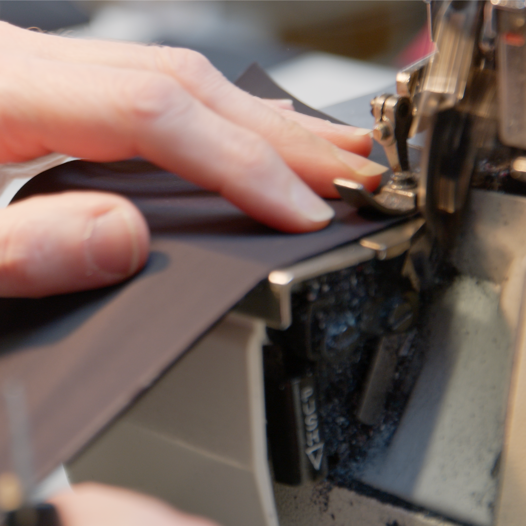 Sewer working with a sewing machine and black stretch fabric