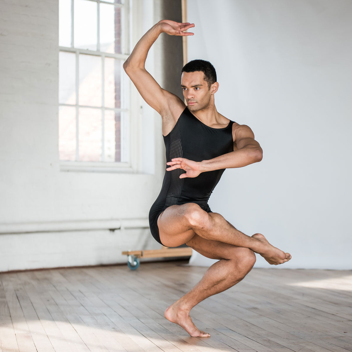 Brandon Lawrence wearing a black biketard with stylish wide neckline with a shaped perforated section running down the sides with a short leg length.