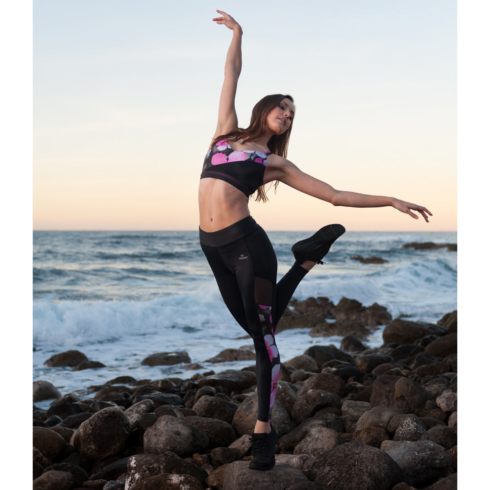 Dancer on rocky beach wearing cloud floral print with black panels This stylish and popular dance bra is now available in our exclusive regenerated fabric!! Double layered front for additional support Two sets of fashionable cross over straps Snug midriff band keeps the top in place Made with sustainable and regenerated planet friendly fabrics π