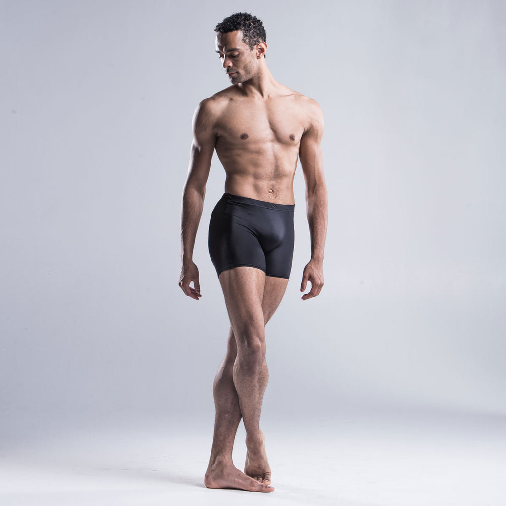 Brandon Lawrence wearing black dancer shorts with no uncomfortable front seam and the wide waste band holds the leggings securely in place.  The perforated side section has a layer of contrast fabric running underneath designed to match the outside feature stitching